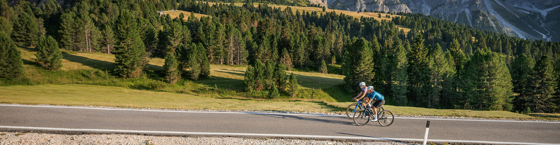 Ciclistas con bicicletas CUBE en carretera de montaña, fotografía original de CUBE
